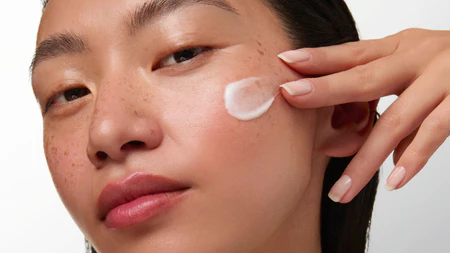 model putting a product swatch on her face